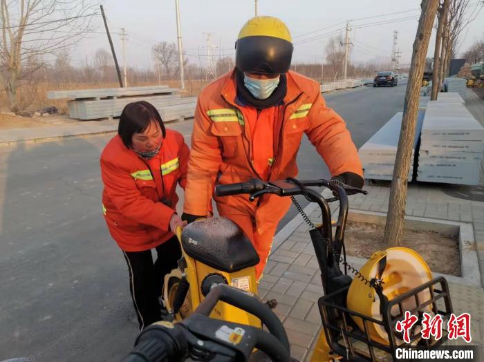 常转香和同事摆放共享电单车。　陆祁国 摄