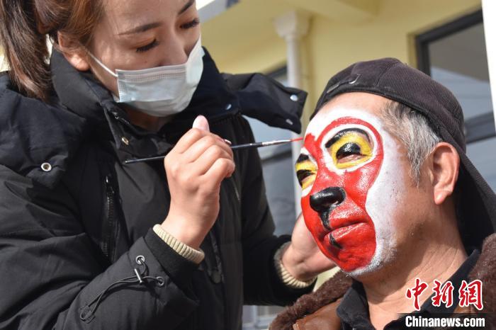 图为“猴打棒”表演者正在化妆。　田立民 摄