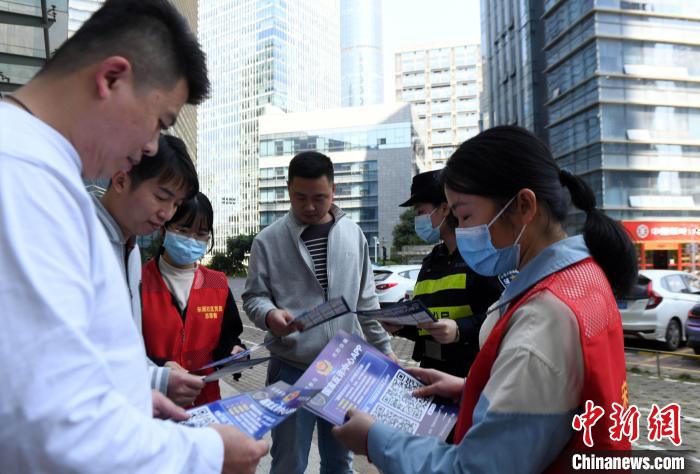 梁慧等“巾帼先锋队”队员和社区志愿者街头开展防电信诈骗宣传。　蒋雪林 摄