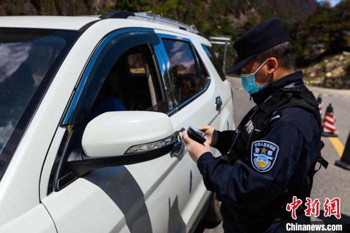 图为桑久执勤点民警正在对过往车辆人员进行查验。　柳春伟 摄