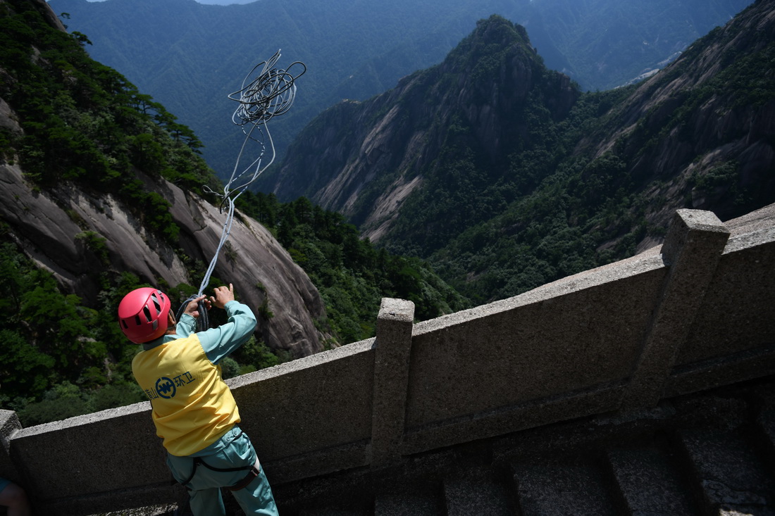 8月14日，李培生在黄山风景区放绳准备清捡垃圾。新华社记者 张端 摄