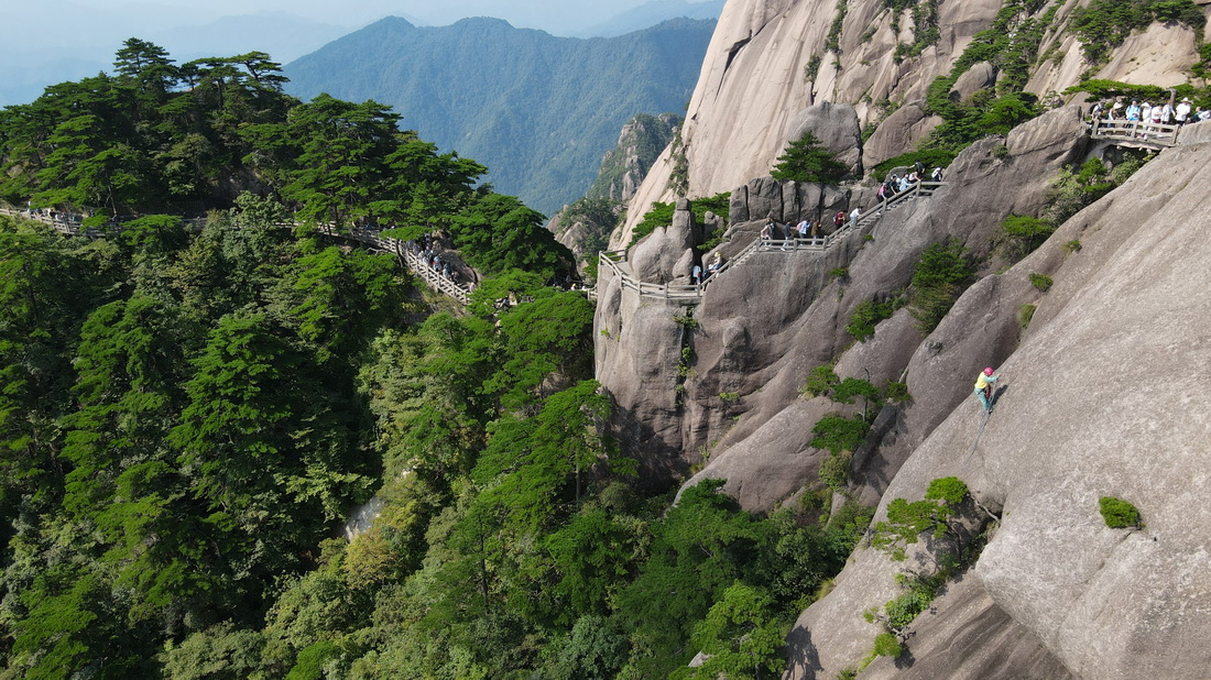 8月15日，李培生在黄山风景区的悬崖峭壁间清捡垃圾（无人机照片）。新华社记者 张端 摄