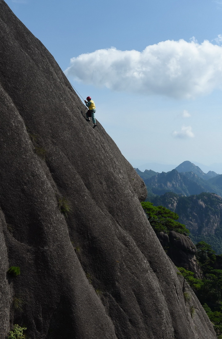 8月15日，李培生在黄山风景区的悬崖峭壁间清捡垃圾。新华社记者 张端 摄