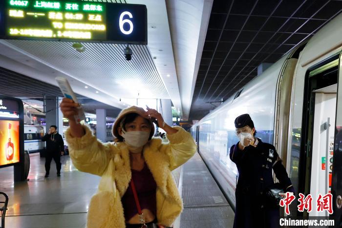 列车长陈怡在铁路上海虹桥站站台上引导旅客就近上车。　殷立勤 摄