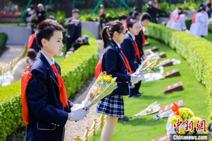 学生代表向烈士墓敬献鲜花。　上海市龙华烈士陵园供图